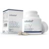 Een witte fles en doos met het label "Cibdol - CBD en CBN Stay Asleep Capsules (30 stuks)" met hop, 5-HTP en CBD-supplementen. De open fles bevat twee capsules aan de voorkant.