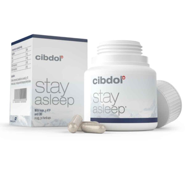 Een witte fles en doos met het label "Cibdol - CBD en CBN Stay Asleep Capsules (30 stuks)" met hop, 5-HTP en CBD-supplementen. De open fles bevat twee capsules aan de voorkant.